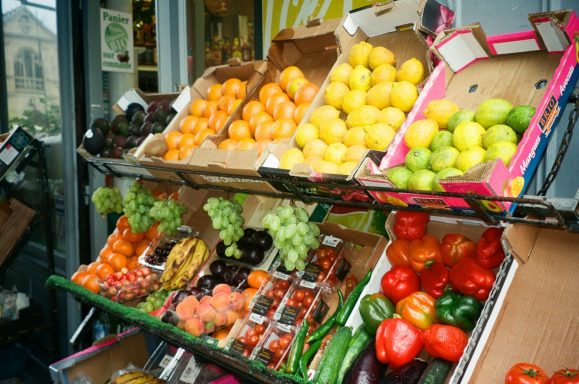 Frutas y verduras frescas dispuestas en cajas en un mercado.