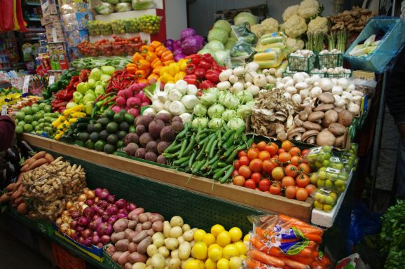 Colorido puesto de mercado con variedad de frutas y verduras frescas.