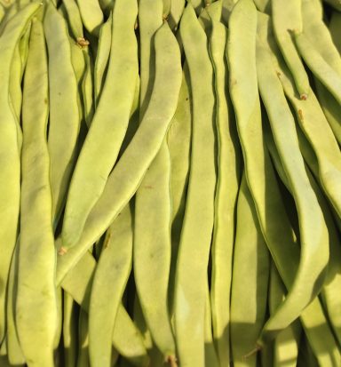 Vainas de judía verde apiladas, de color verde brillante y superficie lisa.